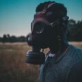 Guy in a gas mask within a field of wheat.